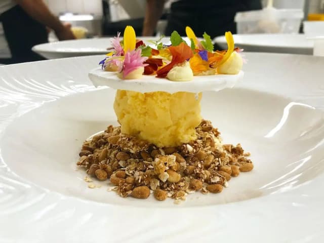 Lemon meringue pie with pine nuts, yuzu, crème fraiche, decorated with flower petals